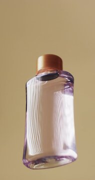 Vertical video of beauty product bottle with copy space on yellow background
