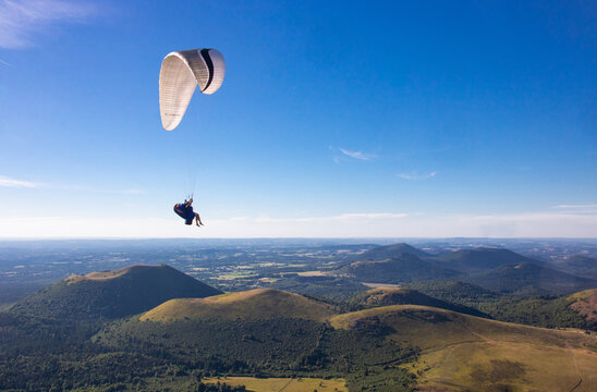 parapente depuis le sommet du Puy-de-D&ocirc;me au dessus des sommets des volcans de la Cha&icirc;ne des Puys dans le Massif Central