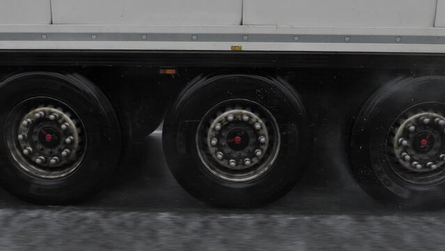 Closeup Truck Wheels Tires Passing on Very Rainy Highway
