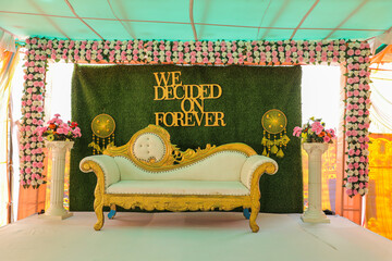 Indian wedding stage decoration setup with luxurious royal sofa chair and flower decoration

