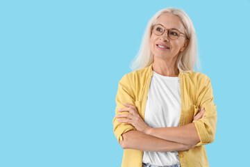 Dreaming mature woman on blue background