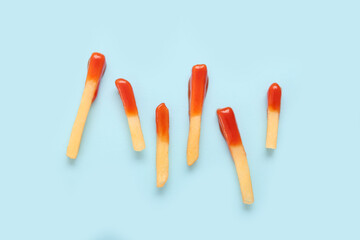 Tasty french fries with ketchup on blue background