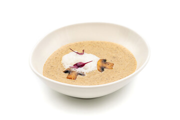 Cream of mushroom soup in white porcelain bowl on white background