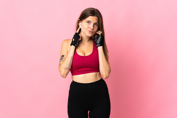 Young slovak woman isolated on pink background listening music and looking to the front