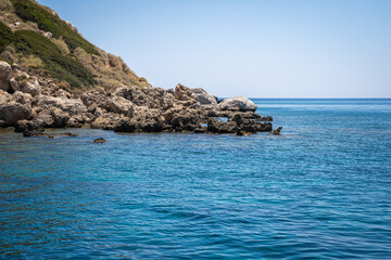 Majestic Rock Formations of Rhodes: A sea-level view of the stunning cliffs and geological wonders along the island's coastline, where the Mediterranean's blue embraces Grecian landscapes.