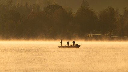 Silhouette of Fishermen on golden autumn morning at Wolfgangsee, Salzkammergut, Austria