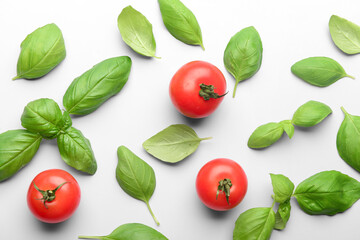 Fresh green basil and tomatoes on grey background