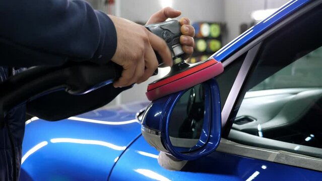 Close-up of a car polishing in a modern car dealership. Car care. A locksmith polishes the car with wax. 