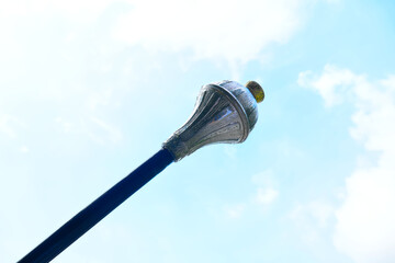 Drum major mace, blue sky with clouds background