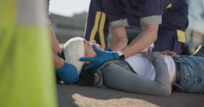 Paramedic team, woman and emergency on road for brain injury, concussion and medical attention. First responder, healthcare expert and accident on street for head bandage, support or safety on ground