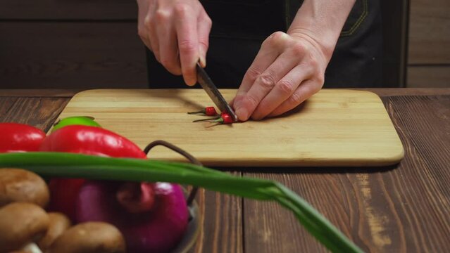 Cutting fresh hot chilli pepper close up