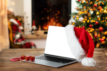 Laptop with blank screen on rustic Christmas interior with fireplace. - Powered by Adobe