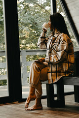 A woman rests and meditates in a house in the forest. Retreat and meditation concept