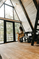 A woman rests and meditates in a house in the forest. Retreat and meditation concept