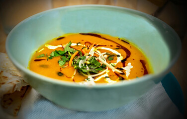 Pumpkin soup with herb and pumpkin oil in bowl. - 659821734