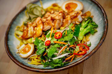 Sweet and sour salad, boiled egg and shrimp with chilli on plate.