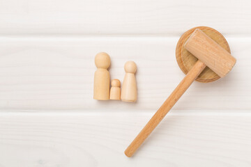 Wooden family figures with judge's gavel on wooden background,top view