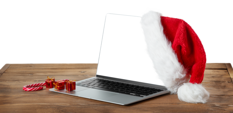 Laptop with blank screen and Santa hat on wooden rustic table. 