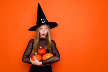Portrait of impressed enchant teenager girl stare arms hold pumpkins empty space isolated on orange color background