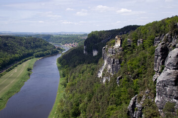 A rocky cliff peeks out from a coniferous forest and the Elbe river in the German national park...