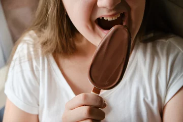 Fotobehang Kid girl eating chocolate ice cream bar © Inna Vlasova