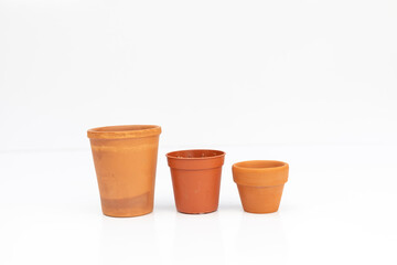 Row of empty terracotta plant pots in different sizes and shapes isolated on white background