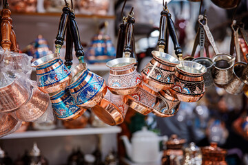 Traditional metal souvenirs at souvenir shop. Copper coffee mugs. Eastern authentic oriental cups. Grand Bazaar in Istanbul, Turkey