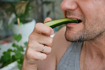 A man bites a cucumber.