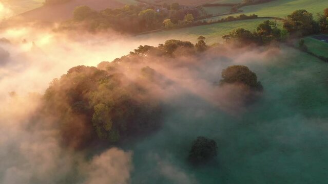 Aerial of mist shrouded countryside at dawn in Exmoor, Somerset, England