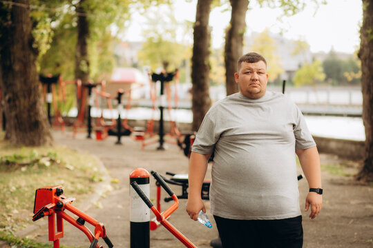 Young overweight man running in park. Fitness lifestyle