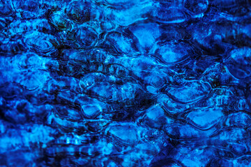 textured natural abstract background, water bubbles under a crust of ice, blue waves and bubbles