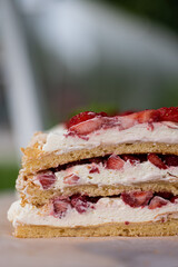 A closeup image of Finnish cake Brita, with fresh strawberries and whipped cream