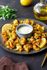 Fried cauliflower with lemon, herbs and white sauce. Healthy eating. Vegetarian food.