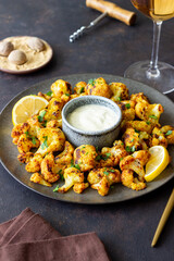 Fried cauliflower with lemon, herbs and white sauce. Healthy eating. Vegetarian food.