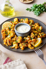 Fried cauliflower with lemon, herbs and white sauce. Healthy eating. Vegetarian food.