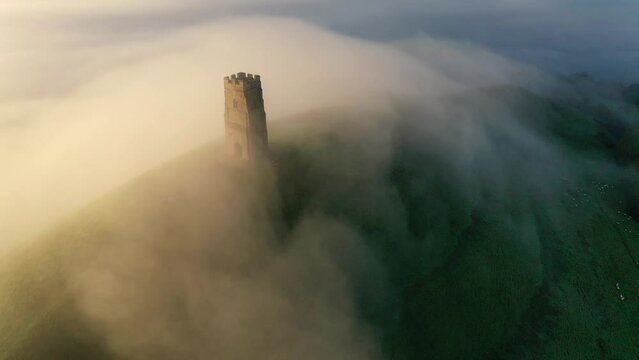 Aerial of Glastonbury Tor on a misty autumn morning above the Somerset Levels, Somerset, England