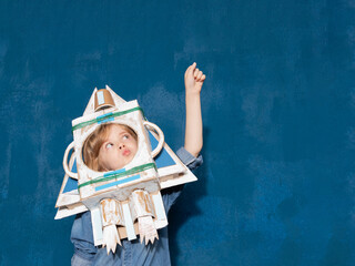 a boy plays as an astronaut with a homemade cardboard rocket. Space child game and education