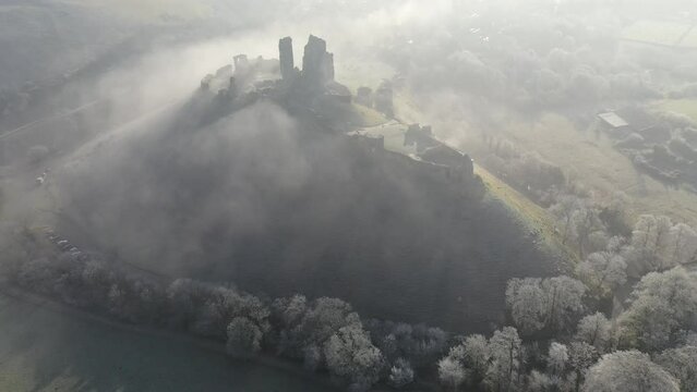 Aerial of Corfe Castle at dawn on a chilly frosty winter morning, Dorset, England
