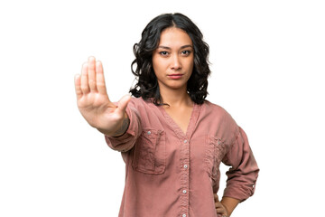 Young Argentinian woman over isolated background making stop gesture and disappointed