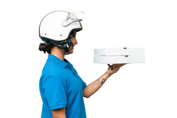 Pizza delivery Argentinian woman with work uniform picking up pizza boxes over isolated background...
