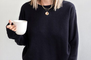 Girl in template blank black sweatshirt home,  coffee design. Black hoodie 18000 model mock up...