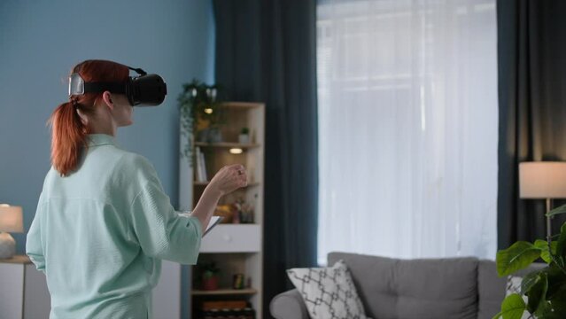 young woman in viar glasses talking to a colleague using augmented reality while standing in cozy room