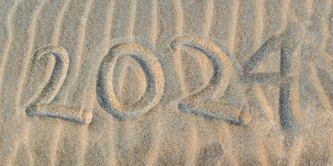 Top view of number 2024 written on the sand of tropical beach