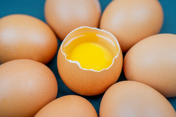 Top view closeup of eggs with one chicken egg broken with yolk