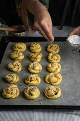 Step by step process of making traditional Swedish cinnamon buns. Sprinkling buns with pearl sugar.
