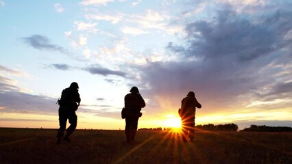 Silhouette of armed soldiers squad running and aiming enemy, military forces fight with arms. Weapon attack operation, war service and assault mission