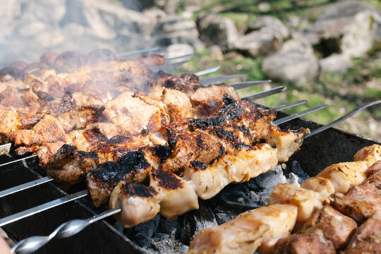 Cooking meat on a skewers. Bbq or barbecue meat. Picnic outdoor. High quality photo.