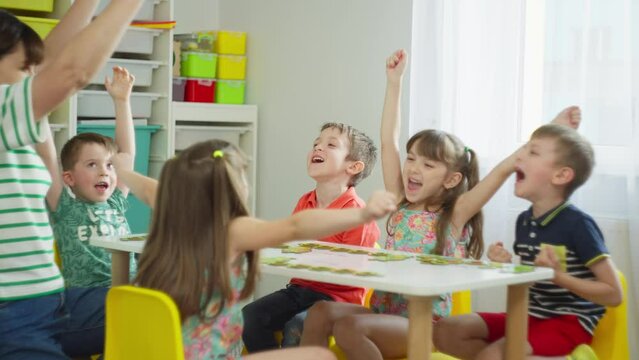 The children and the teacher are happy that they have completed the task. Preparatory classes for primary school. High quality 4k footage