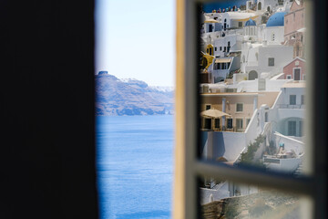 Townscape touristic village reflected on a window glass with a beautiful scenic of Santorini, Greek Islands