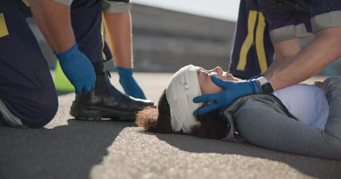 Paramedic team, woman and accident on street for brain injury, concussion and medical attention. First responder, healthcare expert and emergency on road for head bandage, support or safety on ground